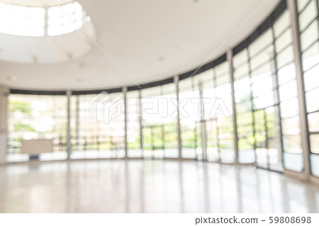 Blur background interior view looking out toward to empty office lobby and entrance doors and glass curtain wall 59808698
