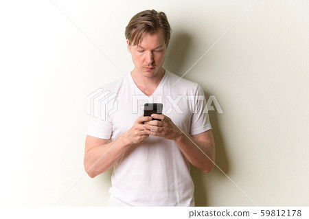 Portrait of young handsome man with long hair using phone Portrait of young handsome man with long hair using phone 59812178