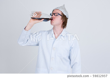 Young man doctor with tinfoil hat drinking bottle of soda 59812937