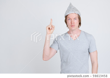 Young man with tinfoil hat as conspiracy theory concept pointing up 59813458