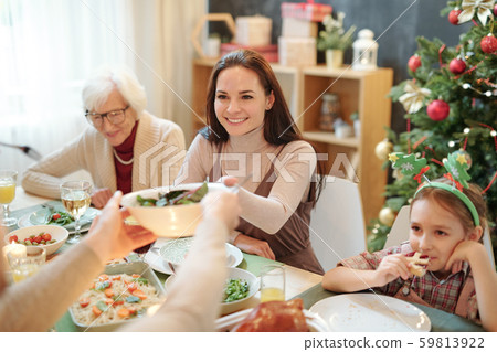 Happy young woman taking bowl with homemade salad from hands of her husband 59813922