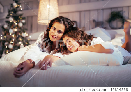 young pretty girls in bed at Christmass morning, happy family smiling lifestyle at holiday young pretty girls in bed at Christmass morning, happy family smiling lifestyle at holiday 59814288
