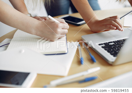 Two girls in a white t-shirts working at the office Two girls in a white t-shirts working at the office 59819455