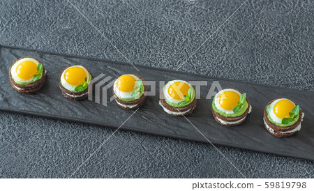 Canape with fried quail eggs 59819798
