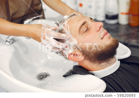Woma washing man's head in a barbershop 59820893