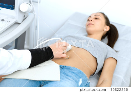 The doctor conducts an ultrasound diagnosis of the The doctor conducts an ultrasound diagnosis of the 59822236