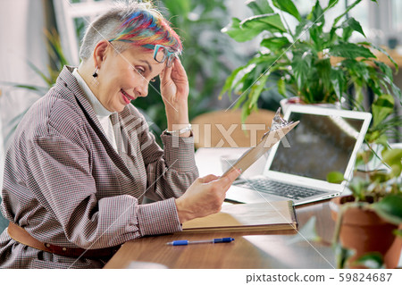 Senior business lady reading document in her workplace Senior business lady reading document in her workplace 59824687