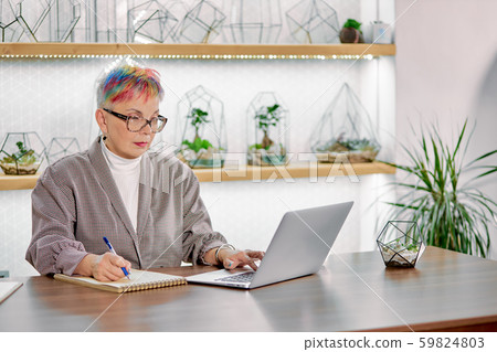Serious mature business lady typing on laptop Serious mature business lady typing on laptop 59824803
