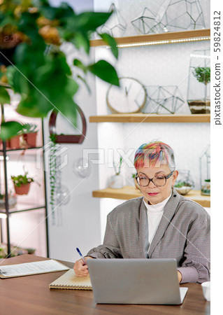 Serious senior business woman writing work issues in notebook Serious senior business woman writing work issues in notebook 59824812