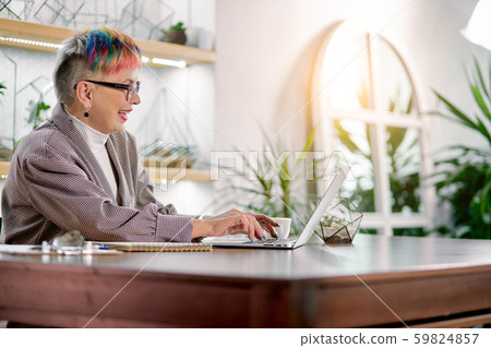 Laugning modern senior lady sitting with laptop Laugning modern senior lady sitting with laptop 59824857