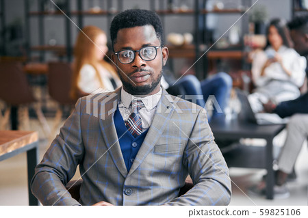 prepossessing man with african appearance in formal suit in office 59825106