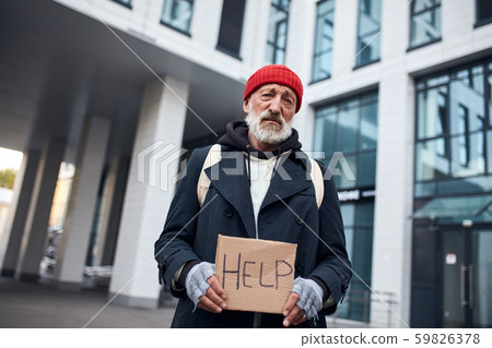 homeless person asks for help in center of city with help sign 59826378