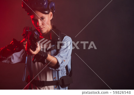 serious woman gamer holding gun isolated in neon backlit serious woman gamer holding gun isolated in neon backlit 59826548
