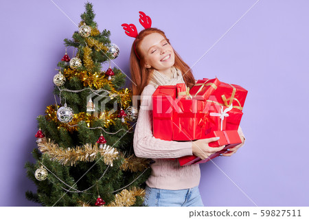 Charming redhead woman carrying gifts 59827511