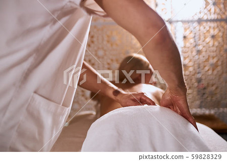 Masseur doing massage on woman body in spa salon Masseur doing massage on woman body in spa salon 59828329