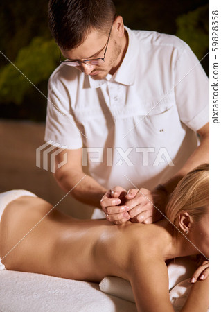 Masseur doing massage on woman back in spa salon 59828358