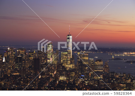 Aerial view of New York City, Lower Manhattan skyline illuminated at sunset. One World Trade Center and Liberty Island, USA Aerial view of New York City, Lower Manhattan skyline illuminated at sunset. One World Trade Center and Liberty Island, USA 59828364
