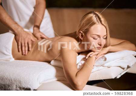 Beautiful cheerful woman lying on massage table Beautiful cheerful woman lying on massage table 59828368