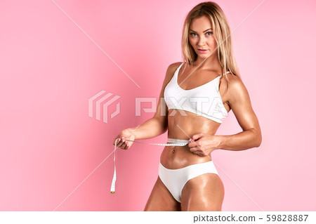 Young lady with measuring tape in hands 59828887