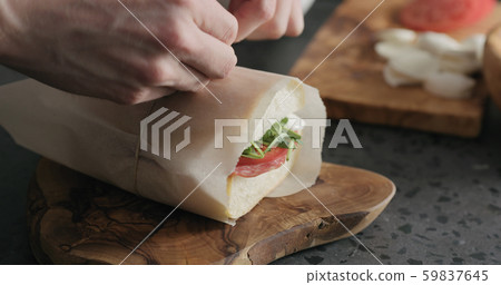 man hands packing ciabatta sandwich with salami and cheese man hands packing ciabatta sandwich with salami and cheese 59837645