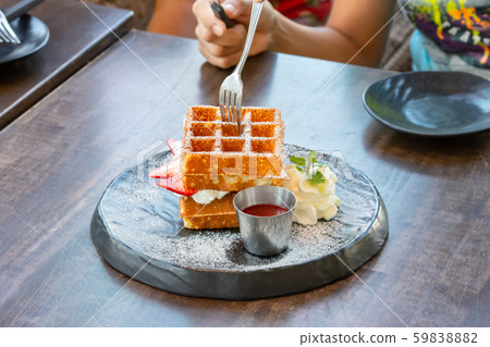 Waffle Strawerry fresh cream in the black plate on wooden table. Waffle Strawerry fresh cream in the black plate on wooden table. 59838882