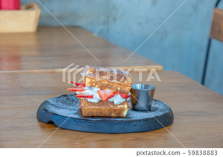 Waffle Strawerry fresh cream in the black plate on wooden table. Waffle Strawerry fresh cream in the black plate on wooden table. 59838883