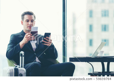 Businessman holding passport and  using smartphone check in air ticket  59839764