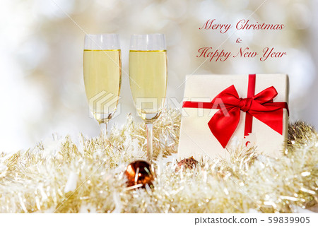 Merry Christmas. Champagne in two glasses and red gift box Merry Christmas. Champagne in two glasses and red gift box 59839905