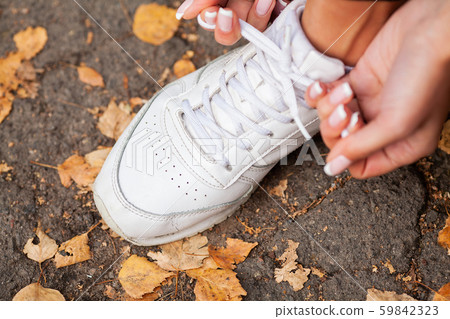 Woman Runner Tightening Shoe Lace. Runner Woman Feet Running On Road Closeup On Shoe Woman Runner Tightening Shoe Lace. Runner Woman Feet Running On Road Closeup On Shoe 59842323