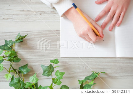 Person writing on notebook 59842324
