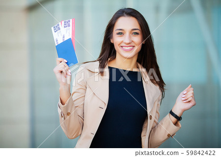Travel. Woman holding two air ticket in abroad passport near airport 59842422