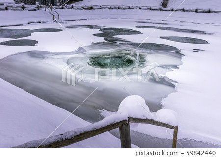 Fish pond with melting ice on water surface 59842440
