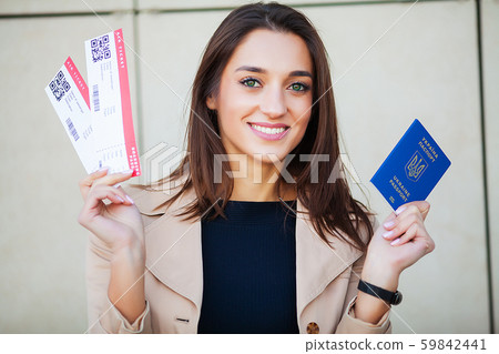 Travel. Woman holding two air ticket in abroad passport near airport 59842441