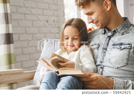 Little kid girl with father at home childhood concept reading book Little kid girl with father at home childhood concept reading book 59842925
