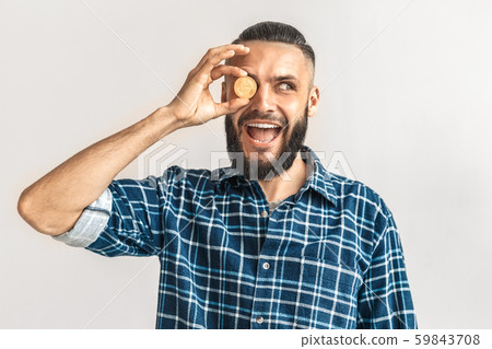 Freestyle. Guy in checkered shirt standing isolated on white holding cryptocurrency coin covering 59843708