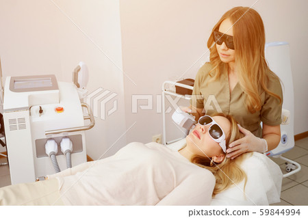 clinic worker performs radical hair removal on girl face clinic worker performs radical hair removal on girl face 59844994