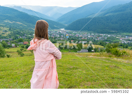 Woman dressed in pink looking on mountains Woman dressed in pink looking on mountains 59845102