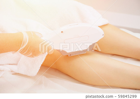 woman hand does laser epilation on leg side part back view woman hand does laser epilation on leg side part back view 59845299