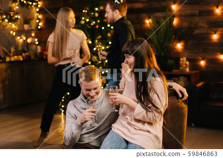 Cheerful man and woman enjoying conversation in festively decorated house 59846863