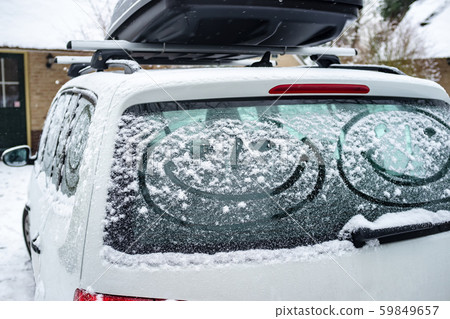Children painted a smiling face on the snow-covered windows of the car. Family vacation during the Children painted a smiling face on the snow-covered windows of the car. Family vacation during the 59849657