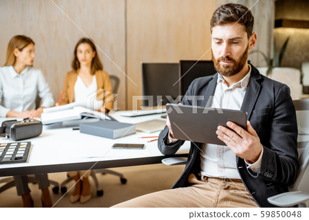 Man working on the digital tablet with colleagues in the office 59850048