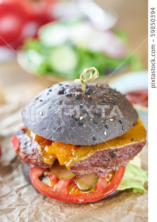Cheeseburger with lettuce, tomato, fries, and melted cheese. The table in the restaurant. Unhealthy Cheeseburger with lettuce, tomato, fries, and melted cheese. The table in the restaurant. Unhealthy 59850394