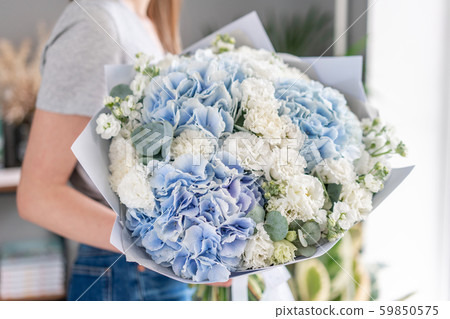 European floral shop. Beautiful bouquet of mixed flowers in womans hands. the work of the florist at 59850575