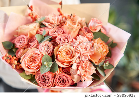 European floral shop. Beautiful bouquet of mixed flowers in womans hands. the work of the florist at 59850922
