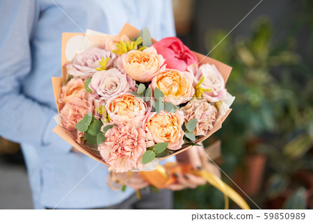 European floral shop. Beautiful bouquet of mixed flowers in womans hands. the work of the florist at European floral shop. Beautiful bouquet of mixed flowers in womans hands. the work of the florist at 59850989
