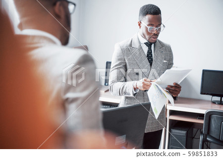 Modern businessman at work. Two confident business people in formalwear discussing something While Modern businessman at work. Two confident business people in formalwear discussing something While 59851833