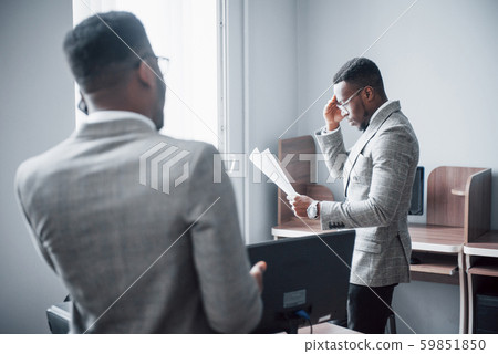 Modern businessman at work. Two confident business people in formalwear discussing something While Modern businessman at work. Two confident business people in formalwear discussing something While 59851850