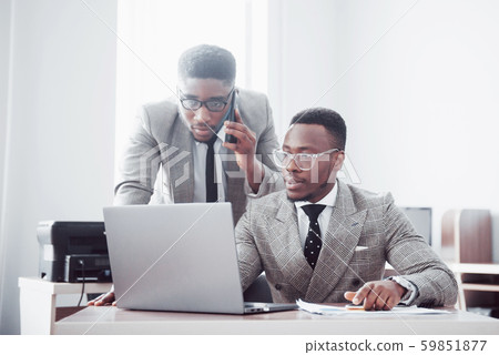 Modern businessman at work. Two confident business people in formalwear discussing something and 59851877