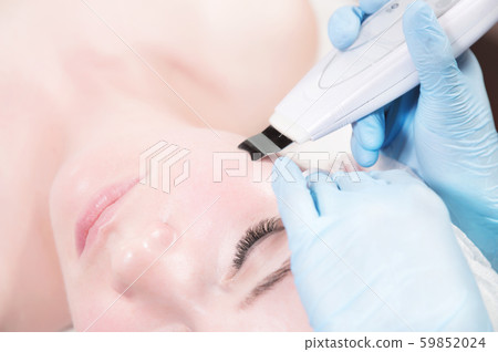 Close-up face of an attractive adult girl in a spa beauty salon at a reception by a professional 59852024