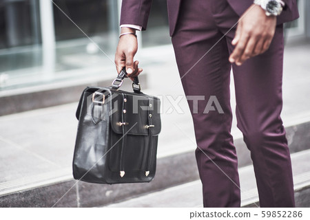 Young businessman with a briefcase near a beautiful office. Business meeting. Young businessman with a briefcase near a beautiful office. Business meeting. 59852286